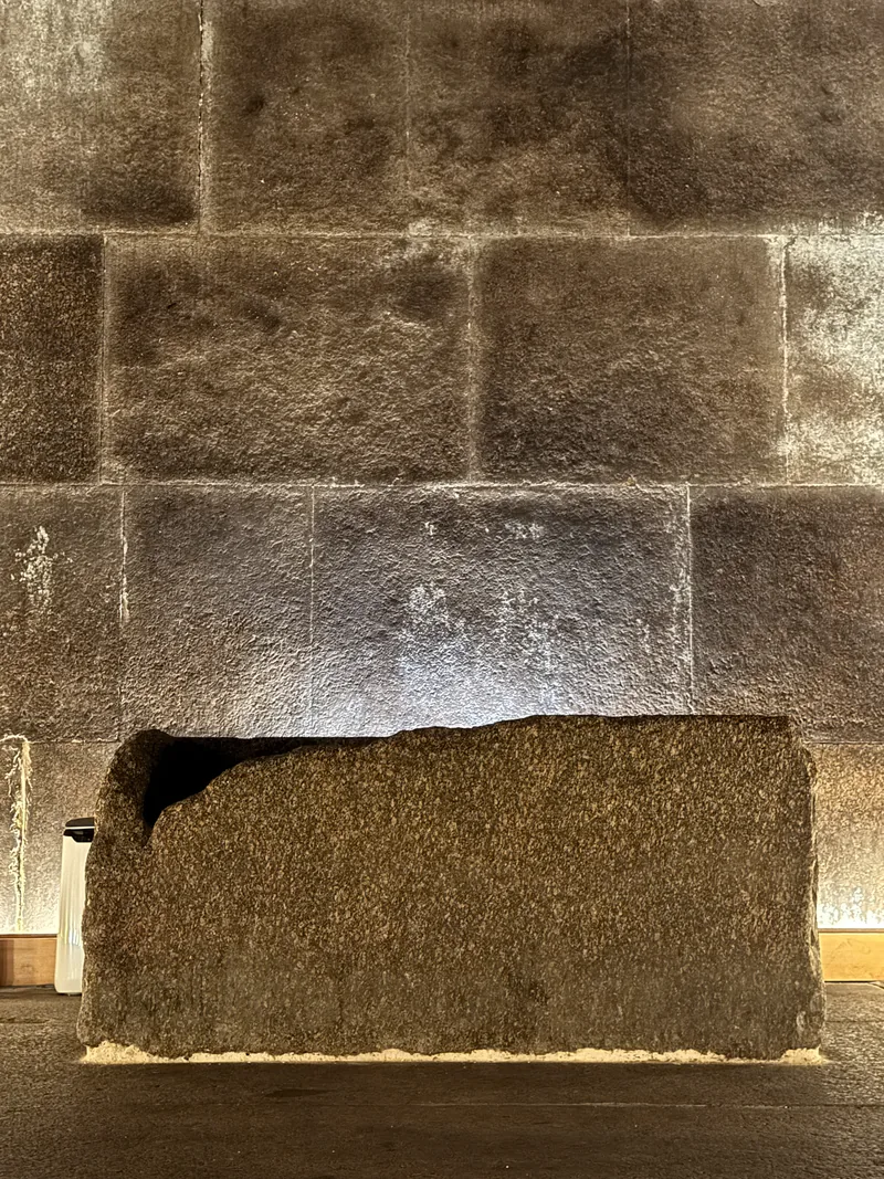 The granite sarcophagus in the King's Chamber, lit against massive stone blocks.