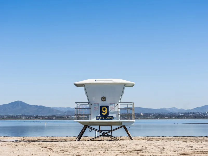 Lifeguard tower 9 on an empty beach with mountains across the bay.