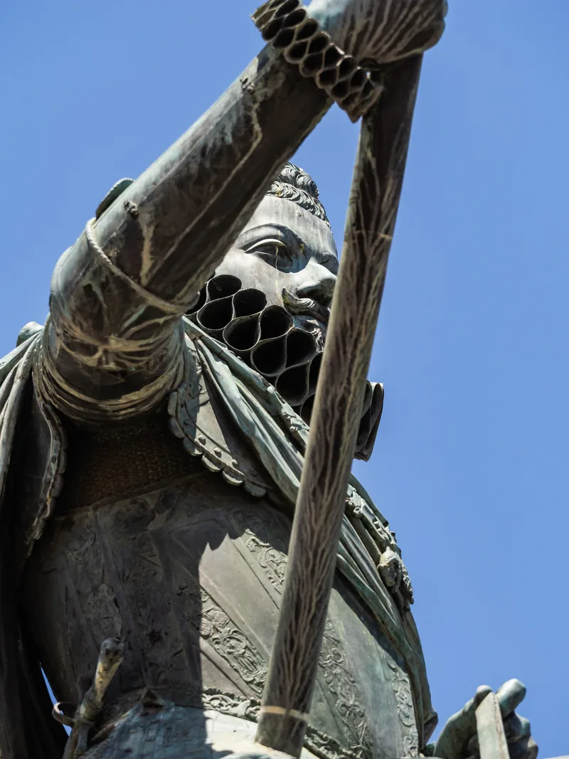 The bronze statue of Philip III in Madrid, seen from below against a blue sky.