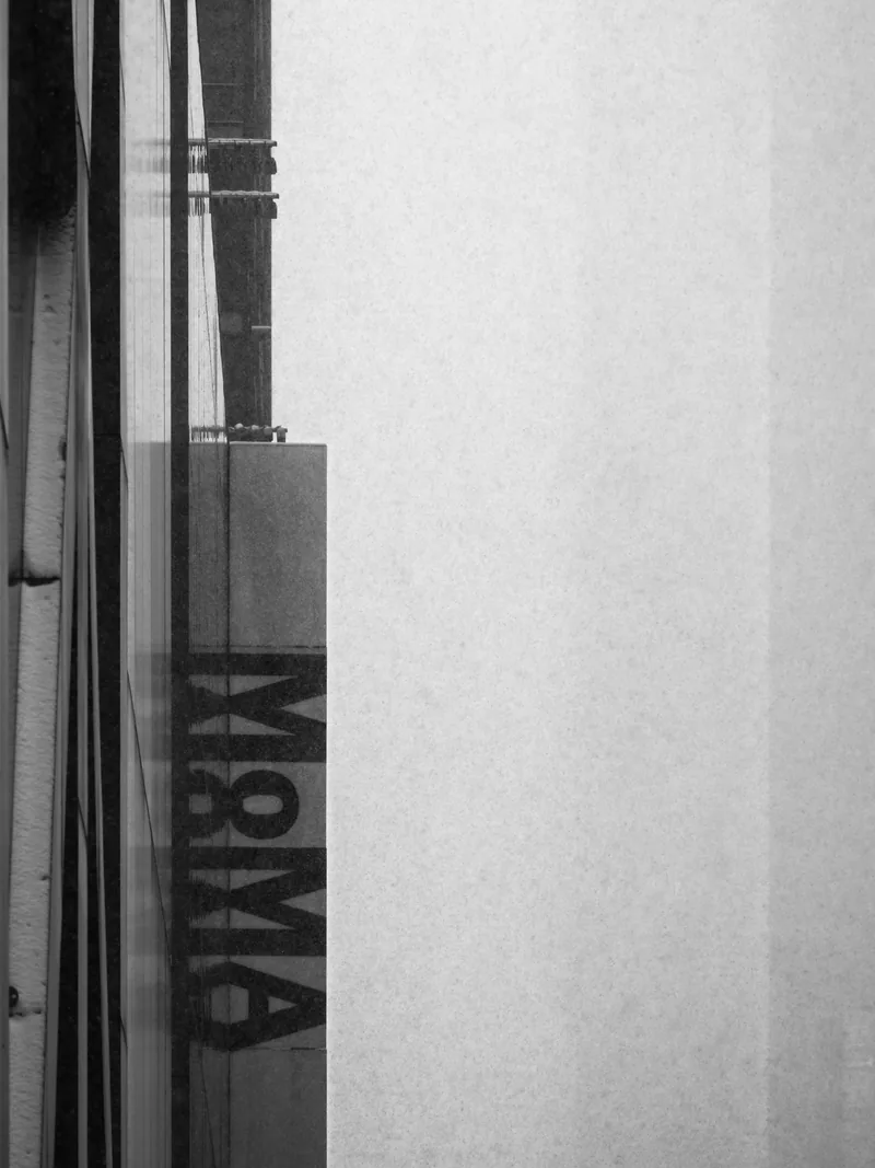 A vertical M&M'S sign on a building edge, softened by snow.