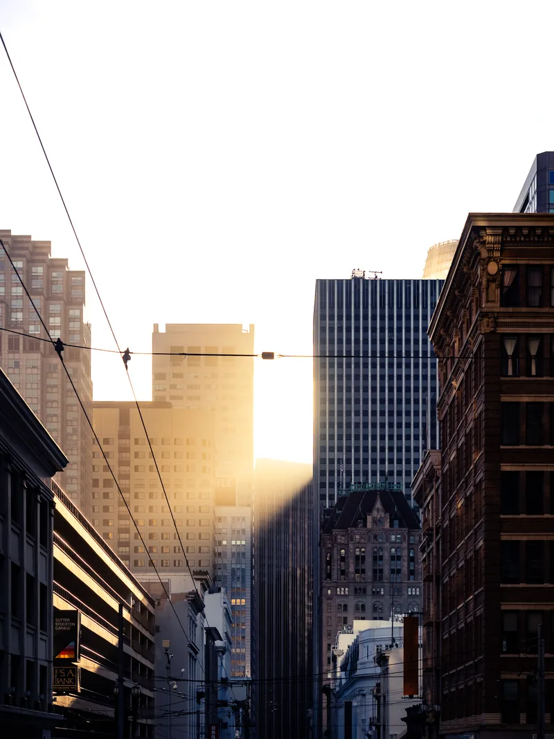 Late sun glowing between downtown buildings.