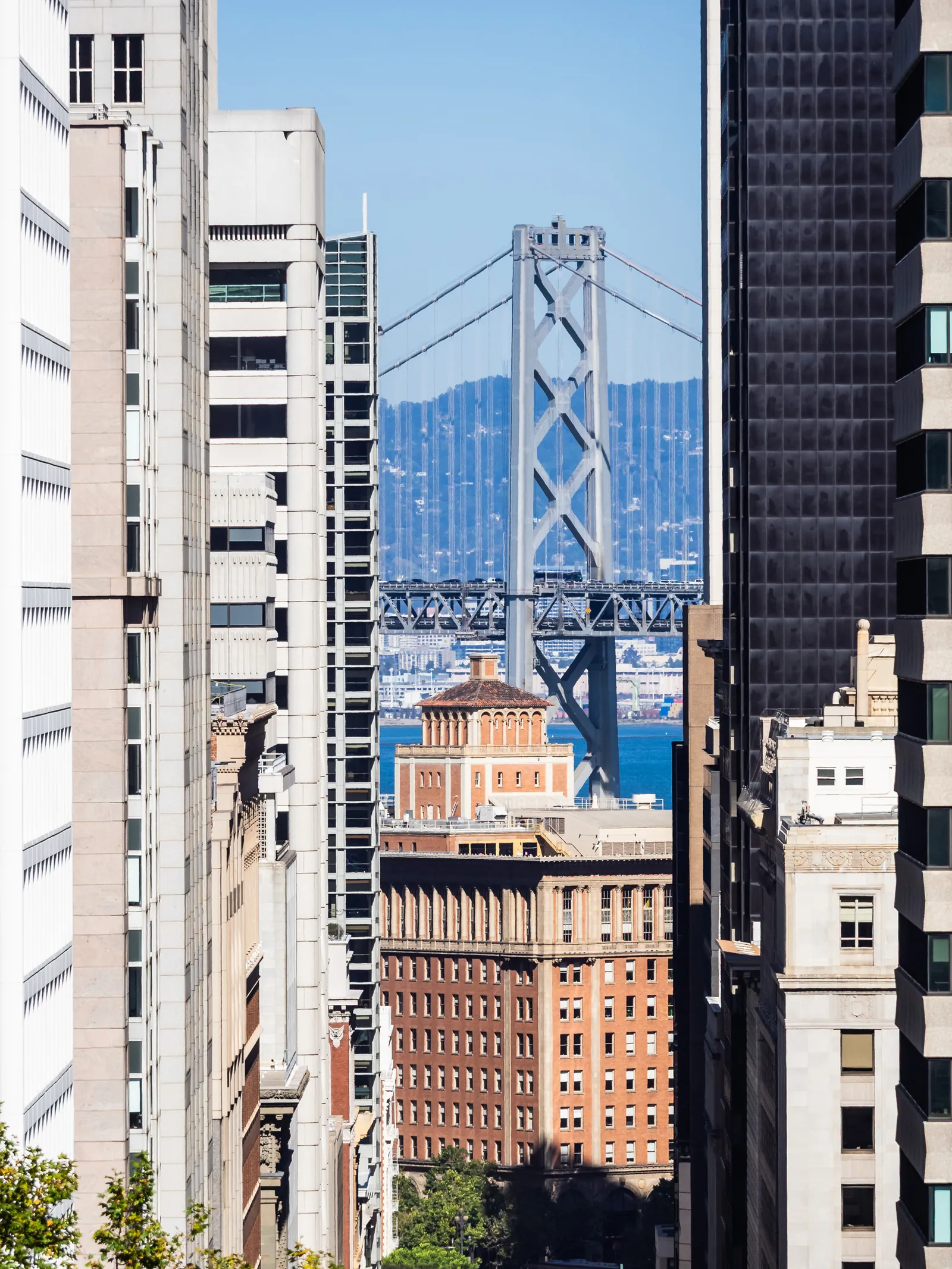 The Bay Bridge framed between downtown San Francisco buildings.