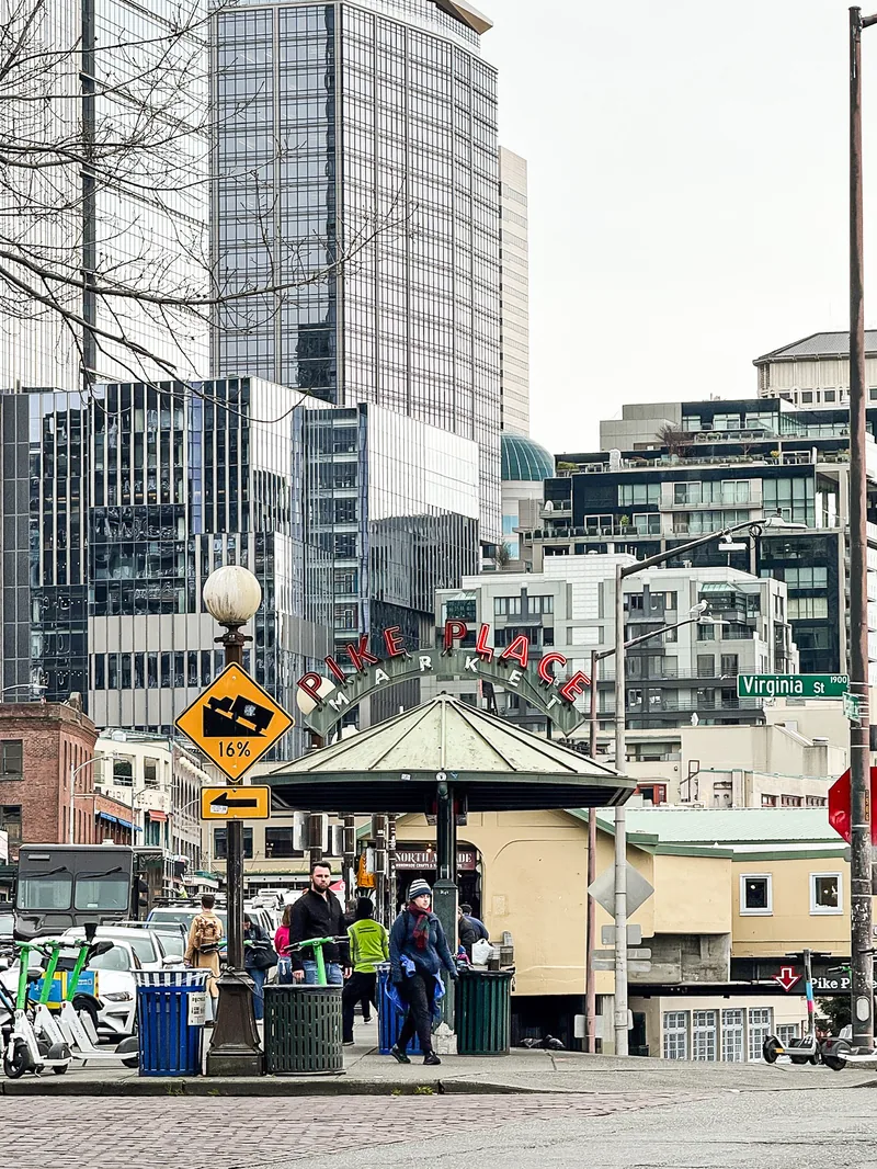 A street corner near Pike Place with a small pavilion and downtown towers behind.