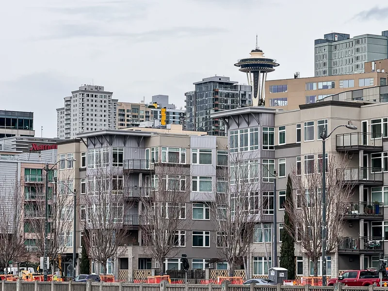 The Space Needle behind a row of apartment buildings.